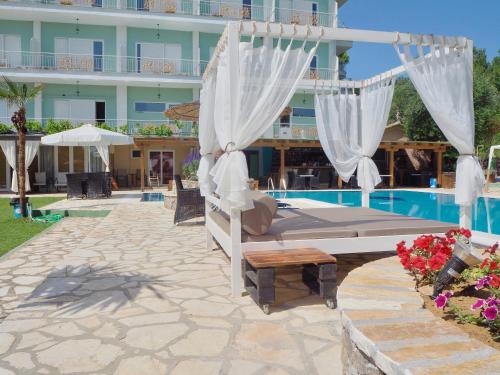 a hotel with a bed next to a pool at Paloma Blanca in Dassia