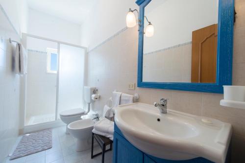 bagno con lavandino, servizi igienici e specchio di Casa Limoncello a Praiano
