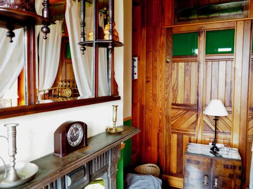 Zimmer mit einer Uhr auf einem Tisch und einem Spiegel in der Unterkunft La Flamenca Inn in Cortelazor