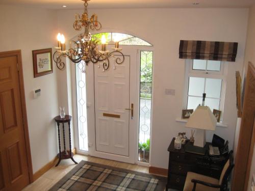 a hallway with a white door and a chandelier at Drumspittal House Guest Accomodation in Armagh