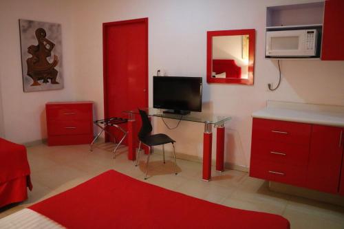 a living room with red cabinets and a television at Zar Manzanillo in Manzanillo