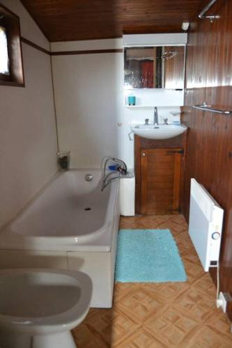 une salle de bain avec une baignoire, un lavabo et des toilettes dans l'établissement Chalet Vintage, à Pollieu