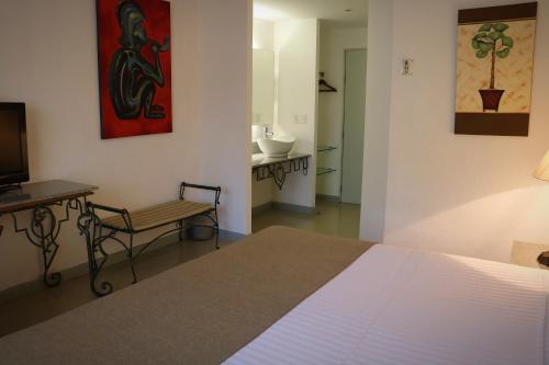 a bedroom with a bed and a chair and a television at Zar Colima in Colima