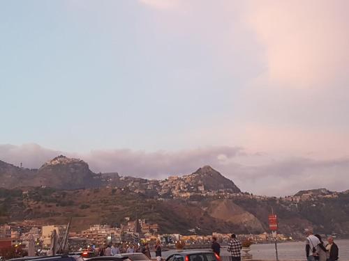 a group of people standing in front of some mountains at Acqua di Mare in Mascali