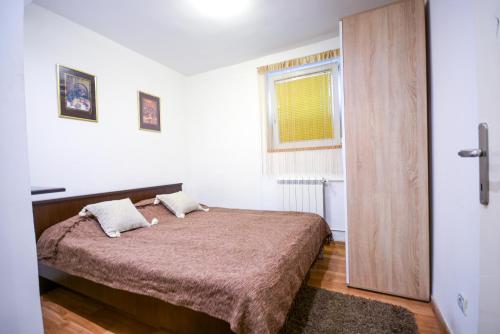 Apartment Marica Skadarlija في بلغراد: غرفة نوم بسرير كبير ونافذة