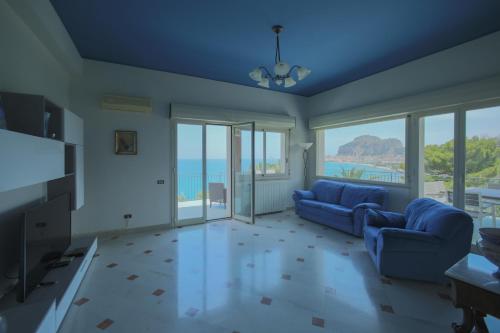 a living room with two blue couches and views of the ocean at La Terrazza sul Mare in Cefalù