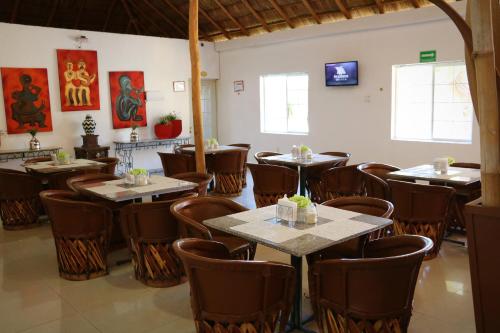 a restaurant with tables and chairs in a room at Zar Colima in Colima