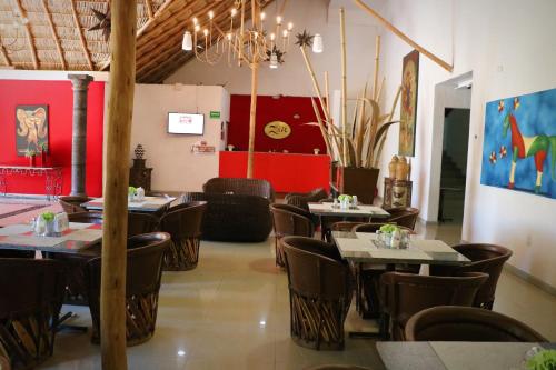 a restaurant with tables and chairs and red walls at Zar Colima in Colima