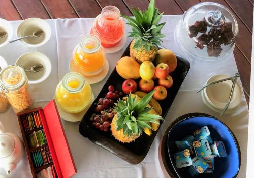a table topped with a tray of fruit and juice at Punta Caracol Acqua Lodge in Bocas del Toro
