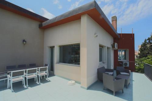 a patio with chairs and tables on a building at La Terrazza sul Mare in Cefalù