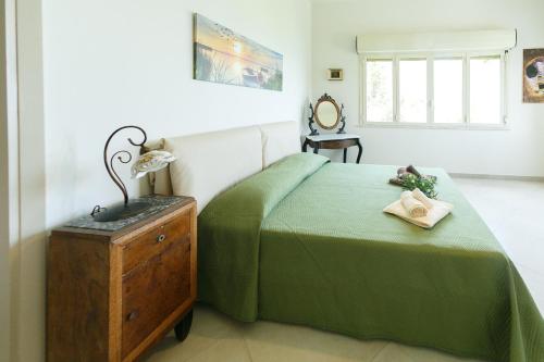 チェファルにあるLa Terrazza sul Mareのベッドルーム1室(緑のベッド1台、ランプ付きドレッサー付)