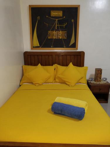 a yellow bed with a blue towel on it at Studio Confort Fann Hock in Dakar