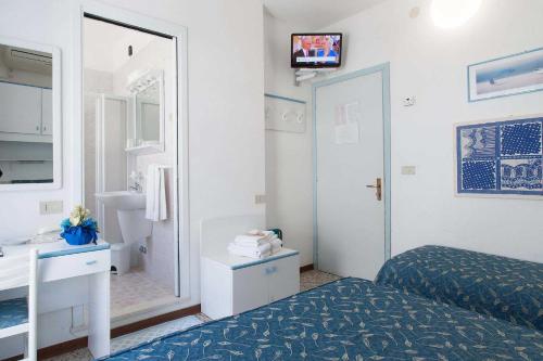 a bedroom with a bed and a sink and a mirror at Hotel Sanremo in Caorle