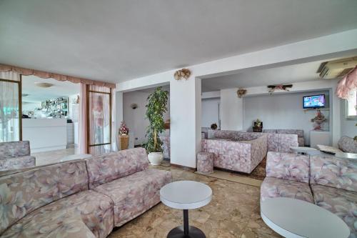 uma sala de estar com um sofá e uma mesa em Hotel Sanremo em Caorle