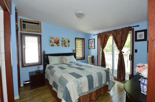 um quarto com paredes azuis, uma cama e uma janela em Ambassador B&B Guest Home em Stratford