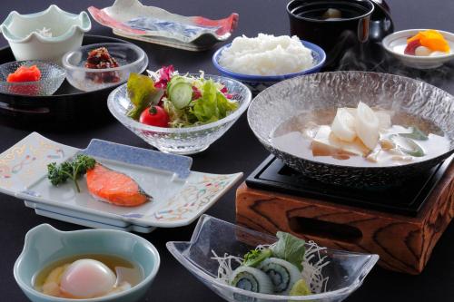 een tafel met kommen en borden met eten erop bij Awara Kitagata Onsen Kohanso Hana Yurari in Awara