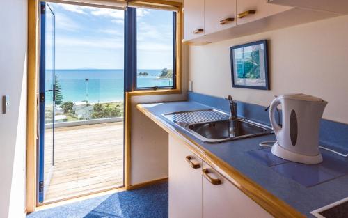 a kitchen with a sink and a view of the ocean at Palm Beach Lodge in Palm Beach