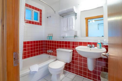 La salle de bains est pourvue de toilettes blanches et d'un lavabo. dans l'établissement Gateway Motel, à Radium Hot Springs