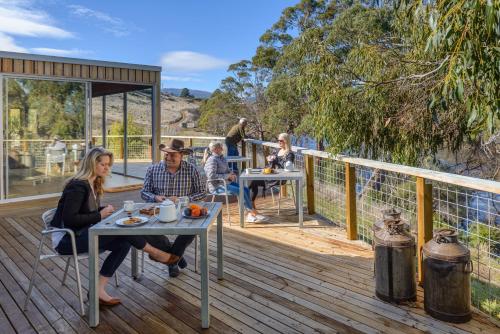 a group of people sitting at tables on a deck at Truffle Lodge Dinner Bed Breakfast Glamping in Gretna
