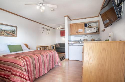 1 dormitorio pequeño con 1 cama y cocina en Gateway Motel, en Radium Hot Springs