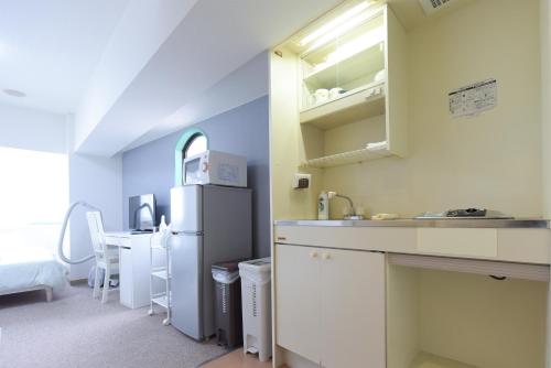 a kitchen with a sink and a refrigerator and a table at HIROKI Building in Tokyo