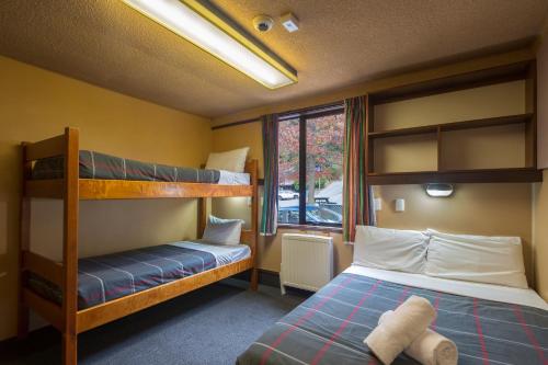 a bedroom with two bunk beds and a window at Pinewood Queenstown in Queenstown