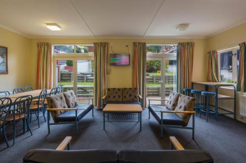 a waiting room with chairs and a table and windows at Pinewood Queenstown in Queenstown