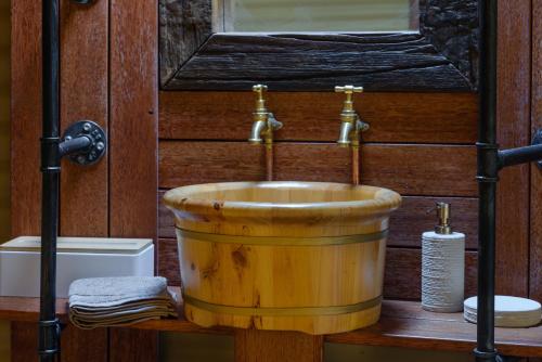 uma banheira de madeira com um lavatório na casa de banho em Truffle Lodge Dinner Bed Breakfast Glamping em Gretna
