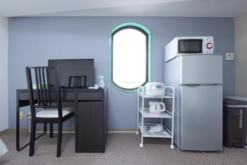 a kitchen with a table and a chair and a refrigerator at HIROKI Building in Tokyo