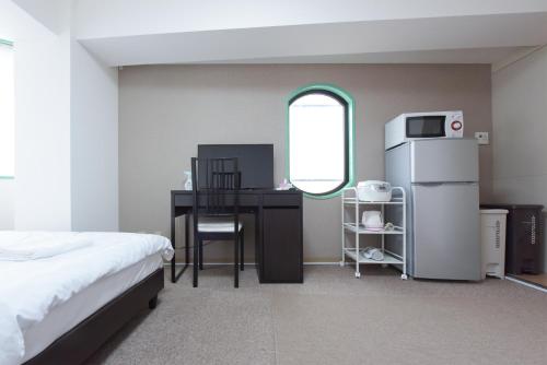 a bedroom with a desk and a refrigerator and a table at HIROKI Building in Tokyo