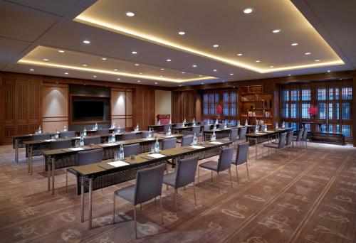 a conference room with tables and chairs and a television at Jinmao Purelax Lijiang, The Unbound Collection By HYATT in Lijiang