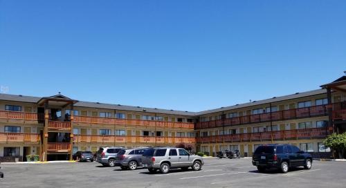 a parking lot with cars parked in front of a building at Nites Inn in Seattle
