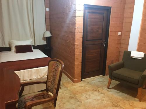a small room with a bed and a chair at Hotel 4 U Saliya Garden in Anuradhapura