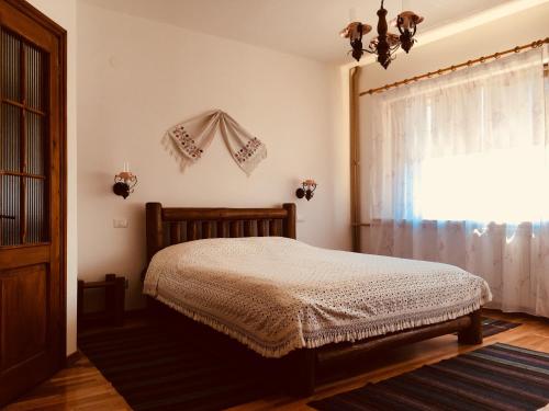 a bedroom with a bed and a window at Pensiunea Ambiance in Piatra Neamţ