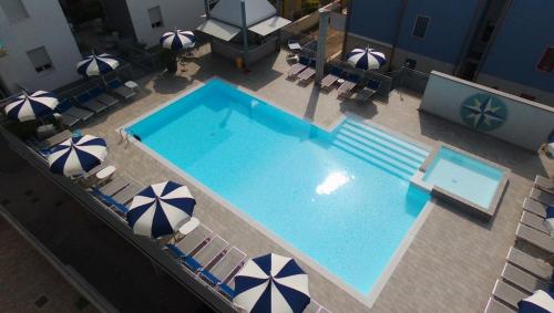an overhead view of a swimming pool with chairs and umbrellas at Hotel Bristol in Caorle