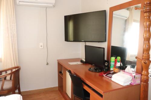 Habitación con escritorio, ordenador y TV. en Orasung Motel en Jeju