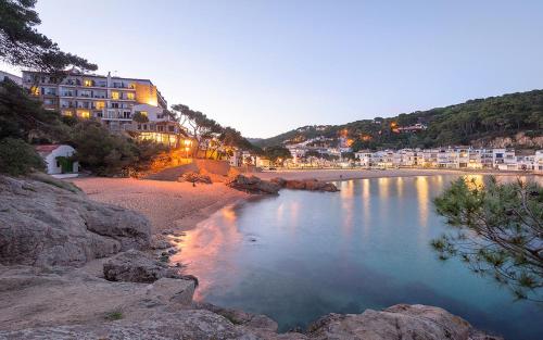 a view of a beach at night with buildings at Hotel Hostalillo in Tamariu