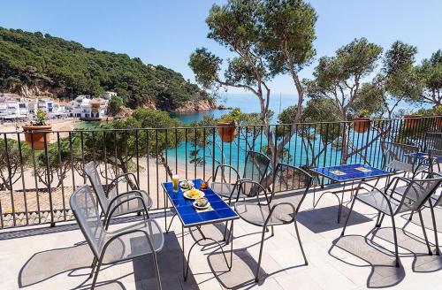 a table and chairs on a balcony with a view of the water at Hotel Hostalillo by Escampa Hotels in Tamariu