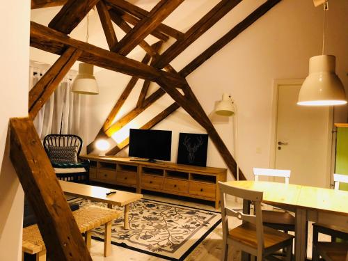 uma sala de estar com uma mesa e uma TV em Bb's Cosy Apartments em Braşov