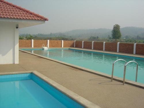 ein großer Pool mit blauem Wasser in einem Gebäude in der Unterkunft Mae Chaem Hotel and Resort in Mae Chaem