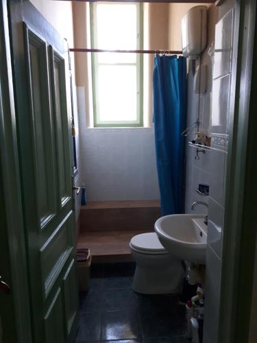a bathroom with a toilet and a sink and a window at Rózsilak in Balatonfüred