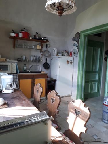 a kitchen with a table and a white refrigerator at Rózsilak in Balatonfüred
