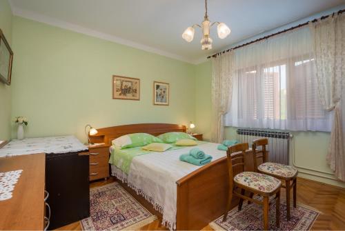 a bedroom with a bed and a desk and two chairs at Apartments Janko in Rovinj