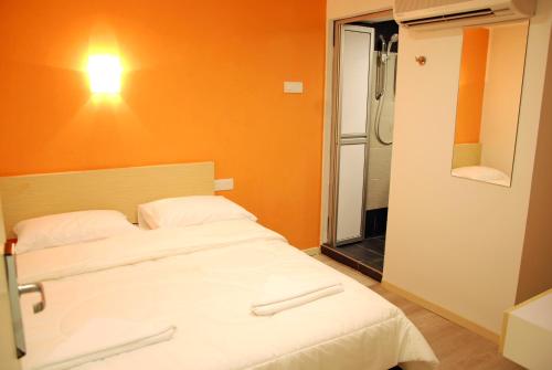 a bedroom with a white bed and a shower at Old Penang Hotel - Penang Times Square in George Town