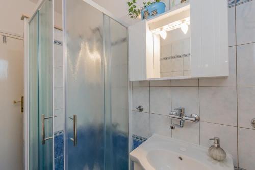 a bathroom with a glass shower and a sink at Apartments Janko in Rovinj