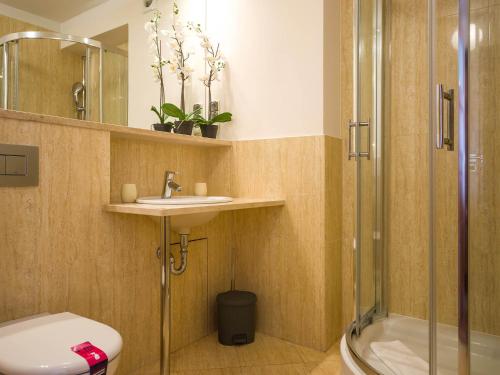 a bathroom with a shower and a toilet and a sink at VacationClub - Villa Mistral Apartment 13 in Świnoujście
