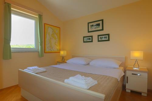 a bedroom with a bed with towels on it at Apartment Klimno View Point in Klimno