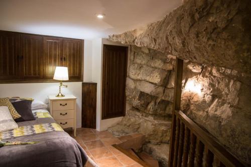 a bedroom with a stone wall with a bed in it at Casa De La Roca in Albarracín