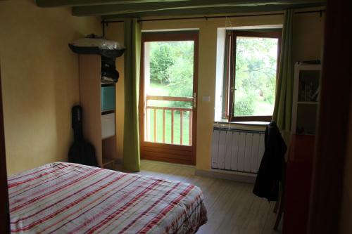 1 dormitorio con 1 cama y ventana con balcón en Le clos des Frasses, en Chainaz-les-Frasses