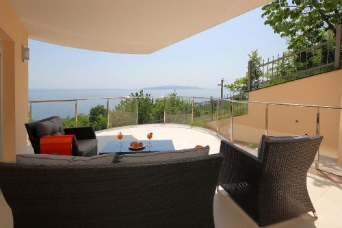 un patio con sedie e un tavolo sul balcone. di Camelia a Opatija